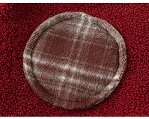 Detailed close-up of warm burgundy fleece fabric with a brown plaid circular patch detail