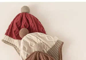 Detailed knit texture of colorful winter earflap hats with pom-poms for toddlers