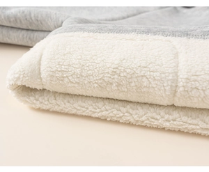 Detailed macro view of gray knitted fabric with thick white sherpa fleece lining