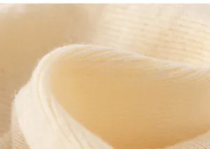 Close-up of soft beige ribbed knit fabric showing fine cashmere texture and cozy fibers