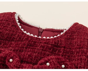 Close-up of girls' tweed dress neckline with white pearl trim and bow detail