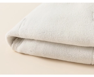 Close-up macro view of thick white coral fleece fabric showing soft plush texture