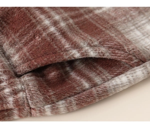 Close-up of red and grey plaid warm fleece fabric texture and fine stitching detail