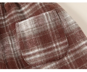 Detailed close-up of brown and white checkered fleece fabric with a soft patch pocket