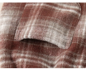 Macro shot of red plaid flannel fabric showing fine stitching and soft brushed texture