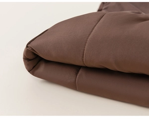 Gros plan détaillé du rembourrage matelassé marron chocolat et des coutures du gilet