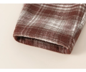 Close-up of red and white checkered flannel fabric with soft texture and neat stitching