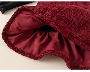 Close-up detail of burgundy tweed fabric with inner lining and black ribbed knit trim
