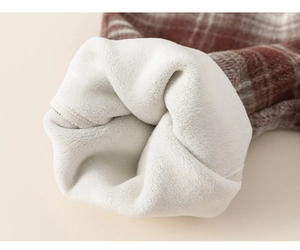 Close-up of winter toddler outfit with thick white sherpa lining and red plaid wool fabric