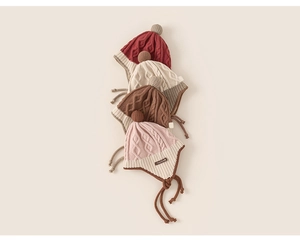 Detailed knit texture and soft pompoms of baby earflap hats in four various colors