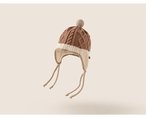 Detail of baby knit hat showing brown cable knit texture and soft beige lining