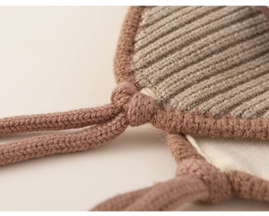 Macro shot of ribbed knit texture and woven drawstring on the warm baby winter hat