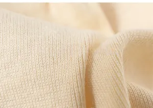 Detailed macro view of high-quality cream knitted fabric showing soft wool texture