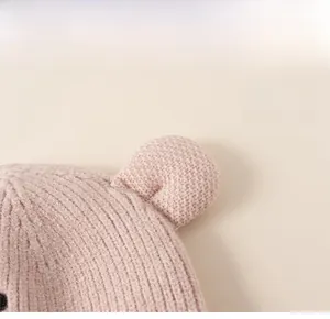 Detail shot of pink knit baby hat featuring cute 3D ears and soft textured fabric