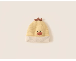 Detailed knit texture of a yellow duckling baby winter hat with soft brown crest
