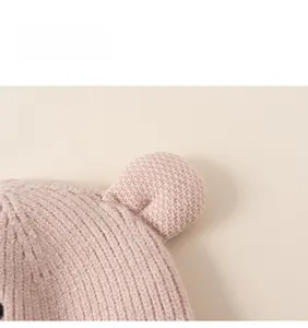 Detailed close-up of light pink knit hat texture and cute 3D bear ear design for kids