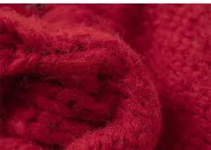 Close-up of thick red knit fabric texture showing warm soft wool fibers and woven patterns