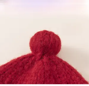 Detailed macro view of the fluffy red pom-pom on top of a soft knit winter hat for kids