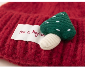 Detailed macro view of the coarse knit texture and mushroom patch on the kids beanie
