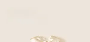 Close-up of champagne satin neckline with bow detail on toddler girl's party dress