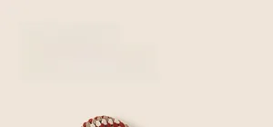 Detailed knit texture of a children's earflap hat with vintage red and brown patterns