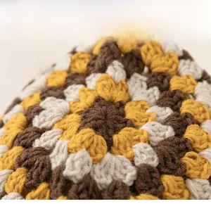 Close-up detail of multi-color granny square crochet texture on kids knitted winter hat