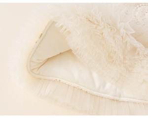 Detail of baby girl party dress featuring ivory mesh layers and warm fleece lining