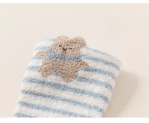 Detail of warm striped coral fleece baby socks with cute 3D bear embroidery decoration