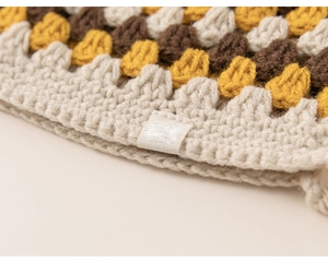 Detail of crochet knit hat edge with wave patterns in beige, yellow and dark coffee