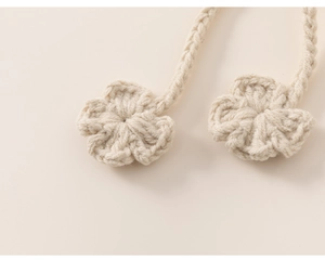 Close-up of handmade crochet flower pendants in beige with detailed knitting texture