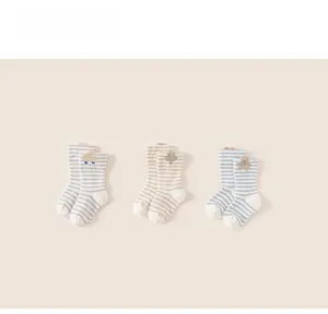 Detailed view of three pairs of thick striped baby socks with cute cartoon embroidery
