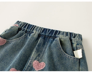 Detailaufnahme von Mädchen-Denimhosen mit rosa Herzstickerei und elastischem Bund