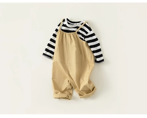 Detailed view of striped long sleeve cotton shirt and khaki overalls with front pocket