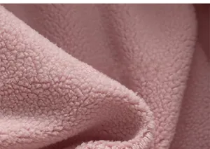 Gros plan sur le tissu polaire sherpa rose doux montrant la texture épaisse et pelucheuse