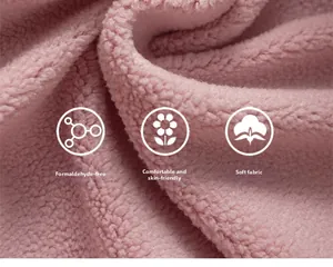 Gros plan sur un tissu polaire corail rose doux, texture respectueuse de la peau et sans formaldéhyde