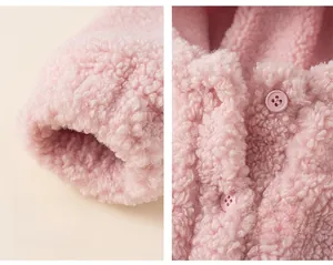 Détails du sweat à capuche en polaire rose avec poignets élastiques et boutons ronds