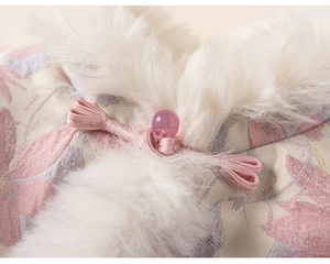 Dettaglio dell'abito floreale rosa con bordo in pelliccia e bottone tradizionale