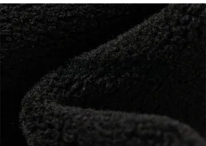 Macro texture of soft black sherpa fleece fabric used for warm hooded sweatshirts