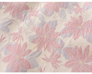 Dettaglio macro del tessuto jacquard con ricami floreali rosa su una base di colore beige