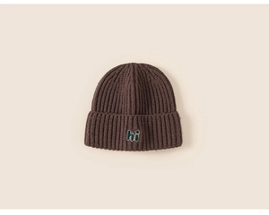 Close-up of thick knit winter beanie in dark brown with embroidered hi detail