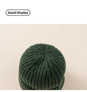 Close-up of the dark green knitted beanie showing detailed vertical ribbed texture and stitching