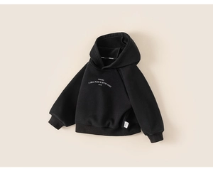 Detail of kid's black fleece hoodie showing soft texture and premium slogan print