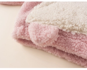 Gros plan du tissu en laine d'agneau rose et blanc montrant la texture épaisse et douce