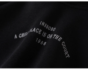 Detailed macro view of vintage sport print on thick black fleece hoodie fabric