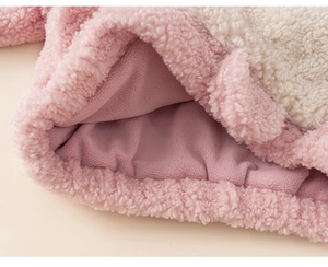 Gros plan sur le tissu pelucheux rose et crème de ce sweat-shirt à capuche thermique