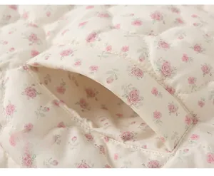 Detail of floral quilted cotton jacket featuring diagonal pocket and pink rose pattern