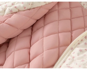Detail of pink quilted girls jacket with floral lining and high quality white zipper
