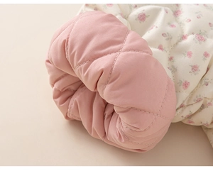 Detail of floral quilted jacket sleeve with pink lining and diamond stitching