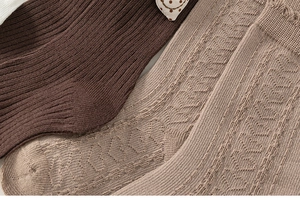 Close-up of children's cotton socks showing ribbed texture and hollow heart patterns