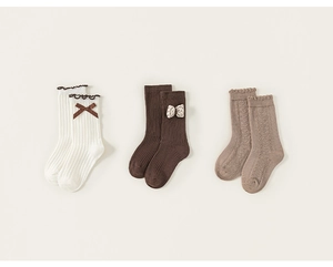 Detailed set of three pairs of kids' ribbed and cable knit socks with bows